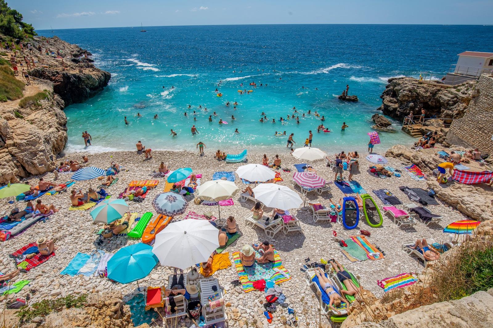 Pulske plaže pune turista koji uživaju u suncu i moru