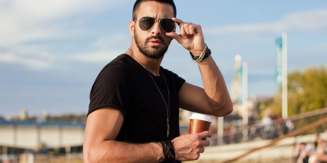 Handsome man outdoors drinking coffee. With sunglasses, a guy with beard. Instagram effect Handsome man outdoors drinking coffee. With sunglasses, a guy with beard. Instagram effect