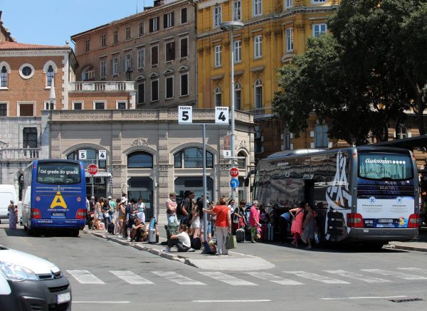 Putnici na autobusnom kolodvoru Rijeka na suncu čekaju prijevoz