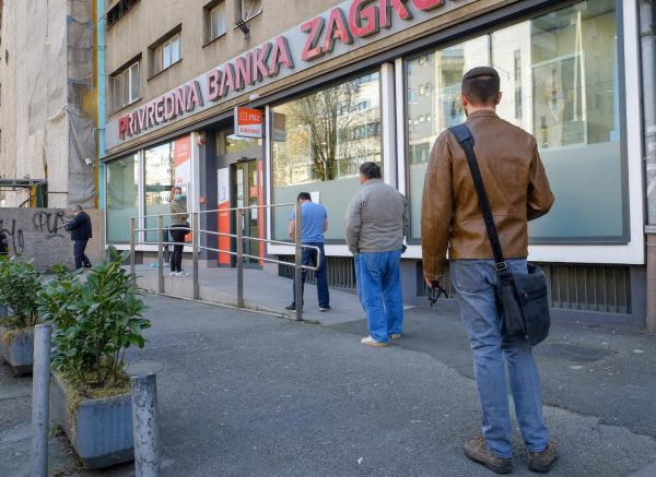 Zagreb: Građani čekaju u redu za ulazak u banku na preporučenom razmaku