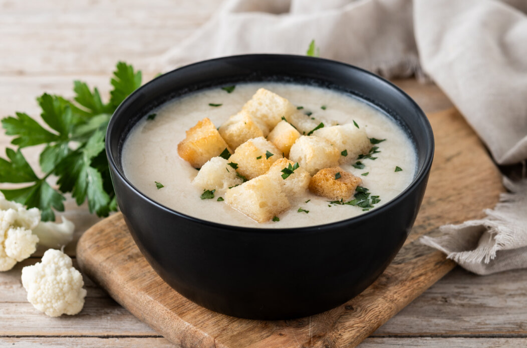 Cauliflower soup in a bowl on wooden table Cauliflower soup in a bowl on wooden table